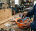 Close-up of a Black Kenyan worker's hands replacing the internal harness cradle of a safety helmet